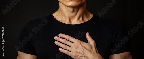 Man in black shirt with hand on chest.