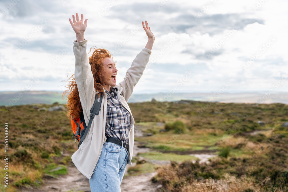 Joyful hiker celebrates reaching the top of a scenic trail in the countryside Joyful hiker celebrates reaching the top of a scenic trail in the countryside