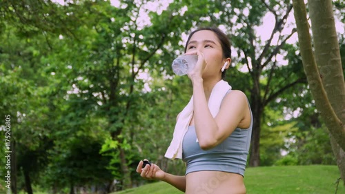Happy healthy woman drinking water from bottle after workout exercise. Sports, nutrition bottle, and female athletes drink liquid for hydration after exercising, a Healthy and active lifestyle concept