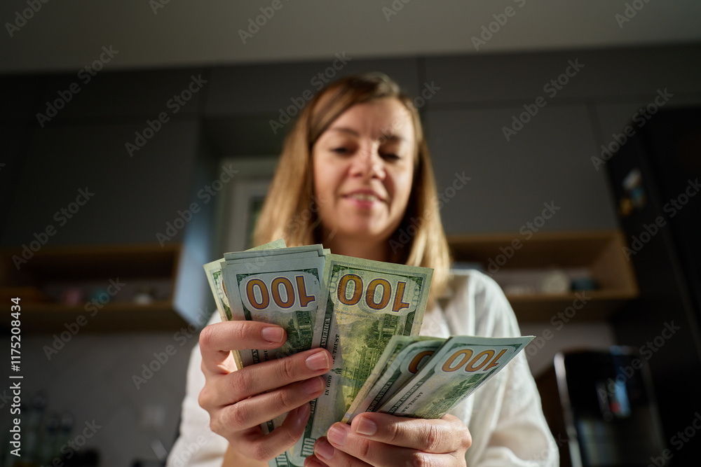 Woman counting stack of dollar bills at home. Female holding american dollars cash. Concept of cash management, wealth or financial transactions Woman counting stack of dollar bills at home. Female holding american dollars cash. Concept of cash management, wealth or financial transactions