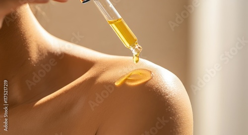 Close-up of light-skinned woman applying oil on shoulder with dropper
