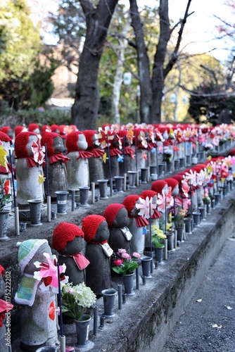 Jizo statue in Tokyo, Japan, a revered figure in Japanese culture known as the protector of travelers and unfortunate children. The serene expression and traditional red bib symbolize compassion  photo