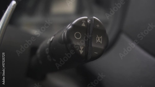 Wipers switch control on steering wheel. Car radio lever switch control paddle on steering wheel. Adjusting speed of screen wipers in car