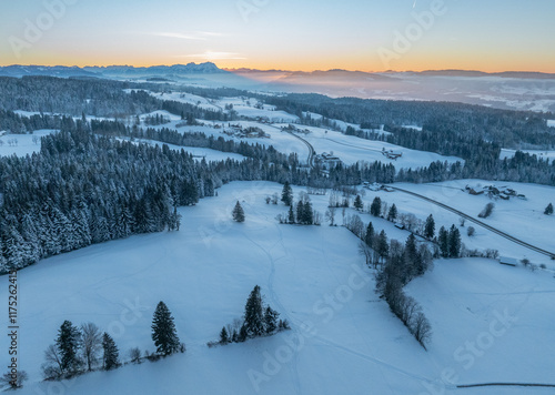 Aerial photo of snowy landscape in moody sunset twilight in the Allgaeu mountains next to Oberreute in Bavaria, Germany  photo