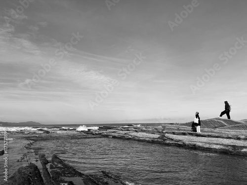 Boy and girl exploring bare beach in Basque country