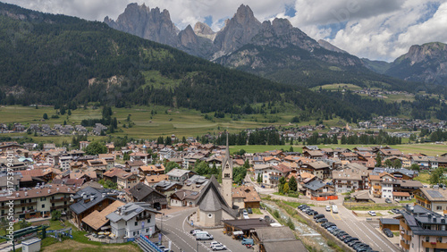 Aerial drone view of the church San Nicolò Meida, Pozza di Fassa in the Val di Fassa valley, Italy. Sunny summer day, Italian Dolomites. Beautiful vacation area with great hiking trails. Mountains. photo