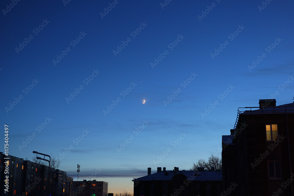 Obraz premium A serene twilight sky with a glowing moon over a stunning urban landscape captivates viewers