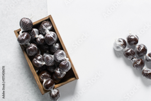 nigerian baba dudu candy in a brown wood box, top view of Ghana coconut candy or kube toffee candy, hard candy made with coconut milk and sugar on granite countertop photo