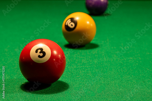 Detalhe das bolas de bilhar numeradas 3, 9 e 12 em mesa de sinuca verde