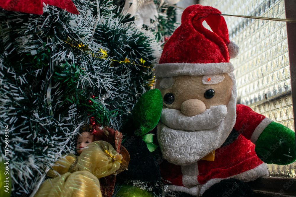 Obraz premium A festive Christmas scene featuring a decorated tree with ornaments, a shining star, plush toys, Santa Claus figurines, and a cozy fireplace. This image captures the warmth and joy of holiday