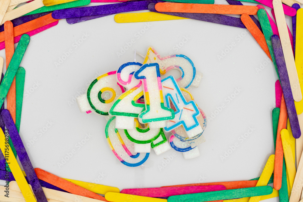 Fototapeta premium Wishing birthday or celebration candles in number shape on white isolated background