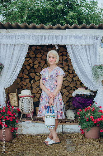 Woman standing in rustic style with firewood and flowers photo