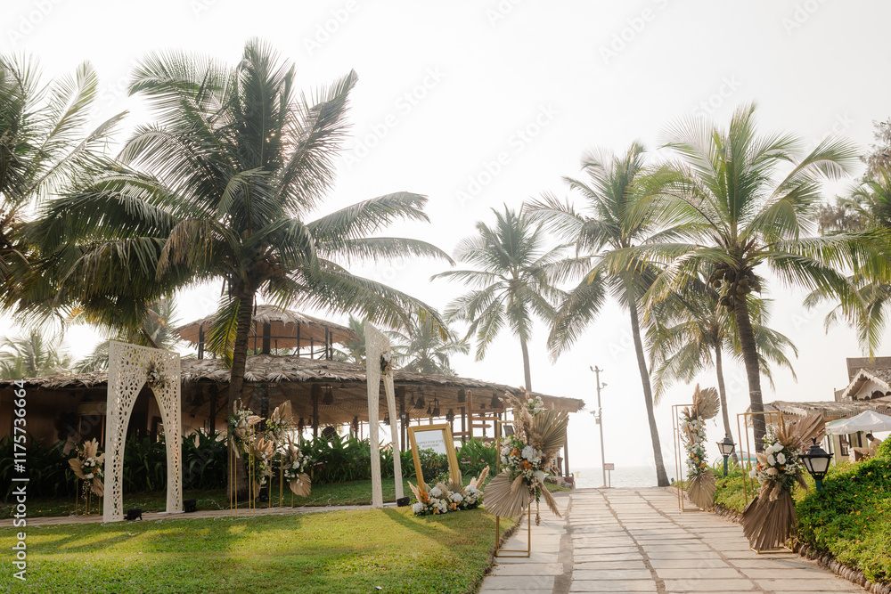 A romantic white beach wedding celebration with an outdoor ceremony, featuring elegant decor, a bottle for colored sand rituals, and a beautifully arranged table under the open sky