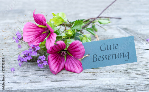 Greeting card with pink mallows and purple verbena and German text: Get well soon