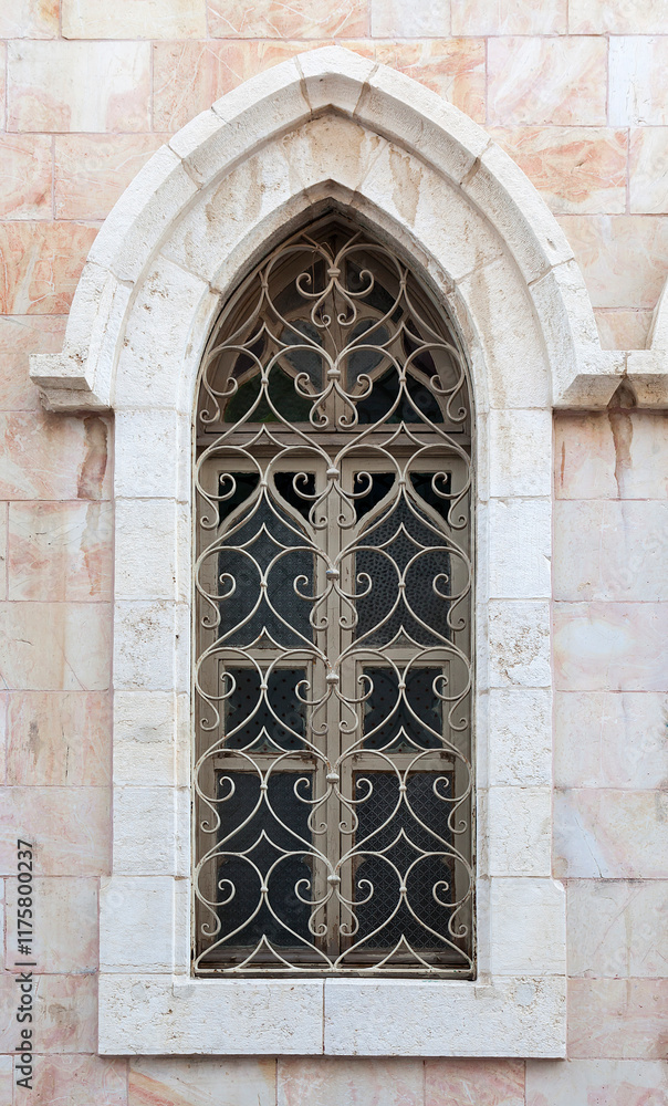 Intricate gothic window design on historic stone building facade Intricate gothic window design on historic stone building facade