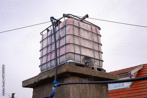 High placed water tank with a capacity of one cubic meter or a thousand liters of water, for the water supply in a hobby greenhouse. photo