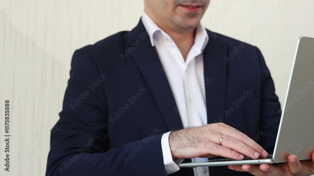 man in business suit is working on laptop sitting against wall.unrecognizable businessman or freelancer typing on keyboard or having a video call. remote job concept.busy worker in office man in business suit is working on laptop sitting against wall.unrecognizable businessman or freelancer typing on keyboard or having a video call. remote job concept.busy worker in office