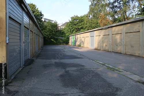 Schilderij op canvas asphalted parking road with garages in a row on the right and left