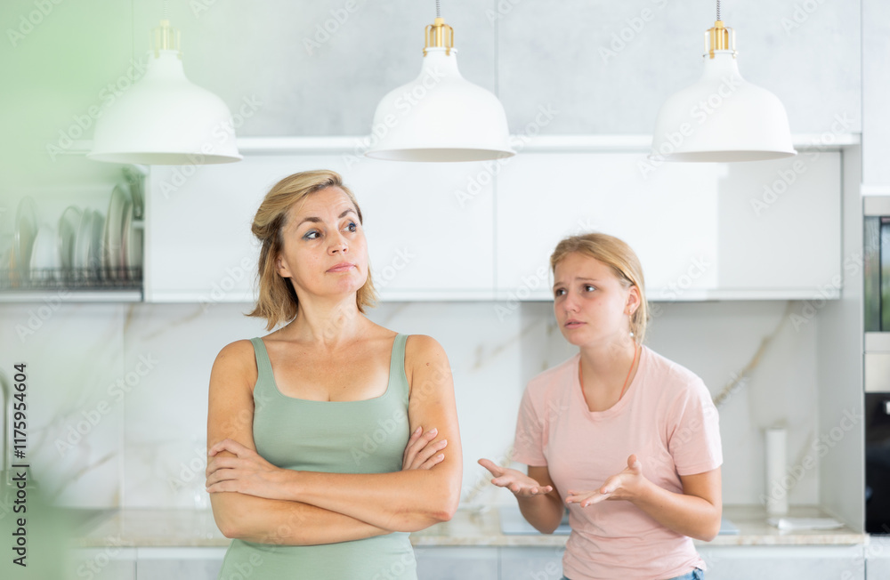 Teenage girl trying to talk and apologize to her offended mother after home disagreements.. Teenage girl trying to talk and apologize to her offended mother after home disagreements..