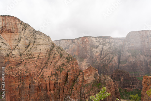 Towering Sandstone Cliffs in Zion National Park Shrouded by Clouds and Mist. photo