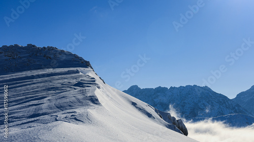 Panorama of the winter peaks of the Tatras from Kasprowy Wierch. A sunny, winter December day. The mountain peaks are covered in thick clouds.