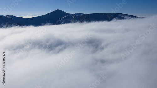 Panorama of the winter peaks of the Tatras from Kasprowy Wierch. A sunny, winter December day. The mountain peaks are covered in thick clouds.