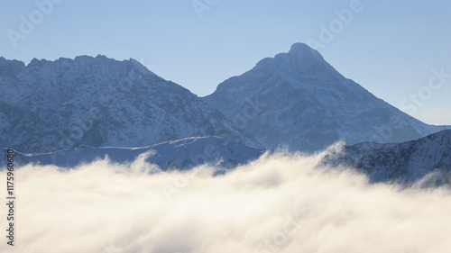 Panorama of the winter peaks of the Tatras from Kasprowy Wierch. A sunny, winter December day. The mountain peaks are covered in thick clouds.