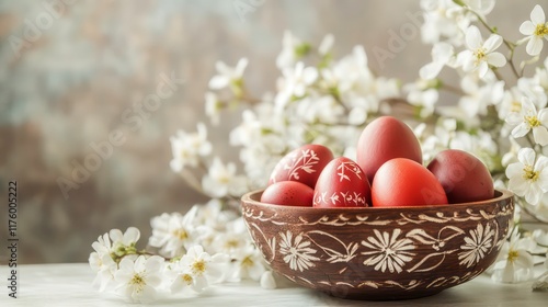 Carved bowl with Easter red eggs on a table decorated with white flowers. Background with space for text