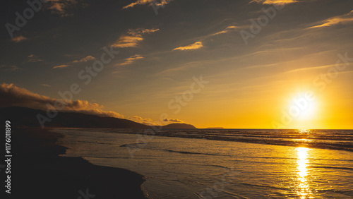 Sunning sunset sun setting into sea ocean water kapiti coast new zealand gold colour photo