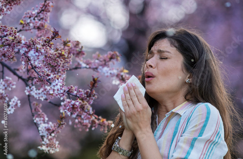 Bilde på lerret Girl sneezing in front of blooming tree in spring