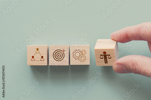 Hand holding wooden block with Ethical icons, business ethics and corporate compliance concept photo