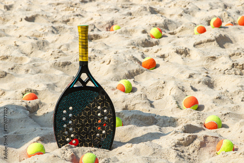 Raquete de beach tennis em pé na areia cercada por bolas para  o jogo photo