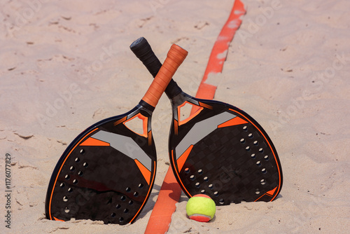 Raquetes e bola para beach tennis na areia com faixa de marcação photo