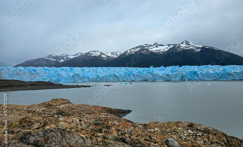 Stunning View of Perito Moreno Glacier’s Vibrant Blue Ice Front with Snow-Capped Andes Mountains and Tranquil Waters in Patagonia, Argentina: A Remarkable Natural Masterpiece photo