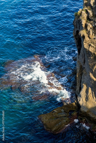 L'onda che si infrange sulla costa rocciosa photo