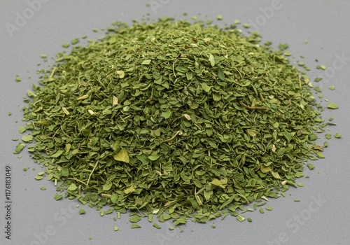 Heap of dried parsley leaves on gray surface for culinary use photo