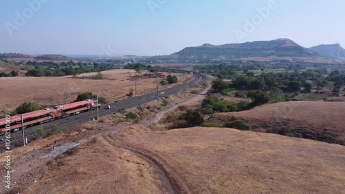 Saffron coloured Vande Bharat Express near Pune India. This is a tri-weekly train between Pune and Kolhapur and also a tri-weekly train between Pune and Hubballi.