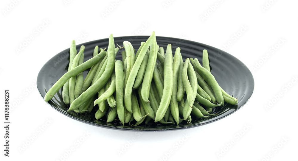 Fresh green beans resting on a black plate on white background Fresh green beans resting on a black plate on white background