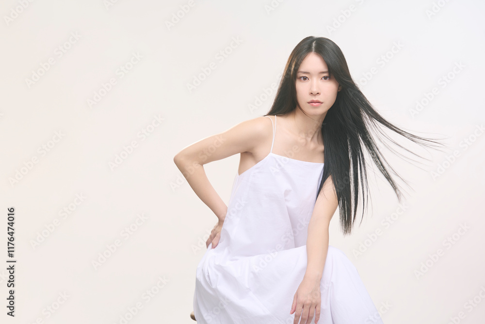 髪が風に靡いている黒髪ロングヘアの女性。