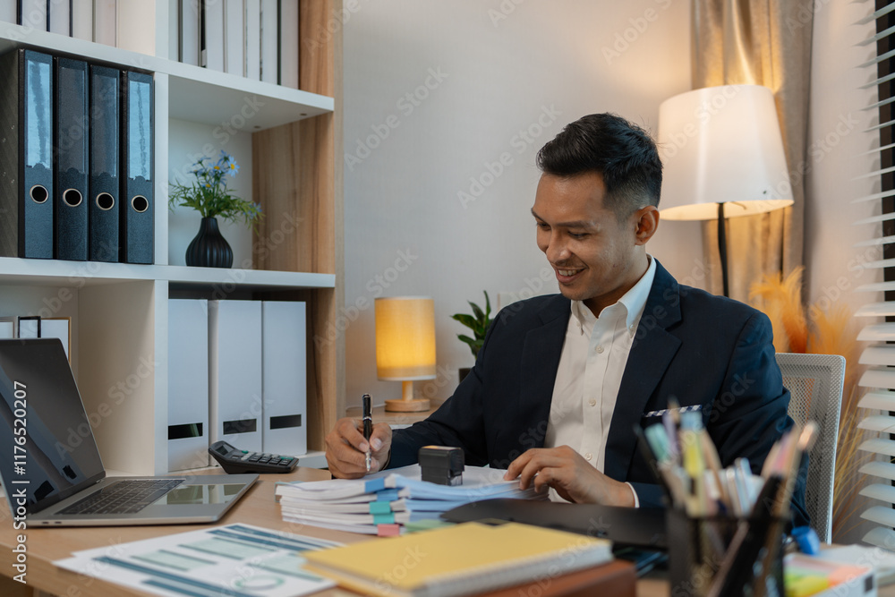 Image of handsome businessman is working in office, cheerful businessman entrepreneur professional working while sitting at office desk, accountant, marketing, employee is working alone in the office Image of handsome businessman is working in office, cheerful businessman entrepreneur professional working while sitting at office desk, accountant, marketing, employee is working alone in the office