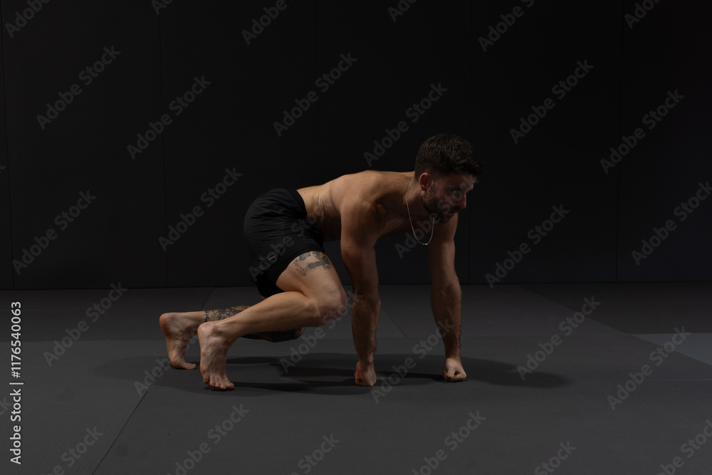 Obraz premium Personal trainer doing his indoor workout at the gym. His technique is called flow moves