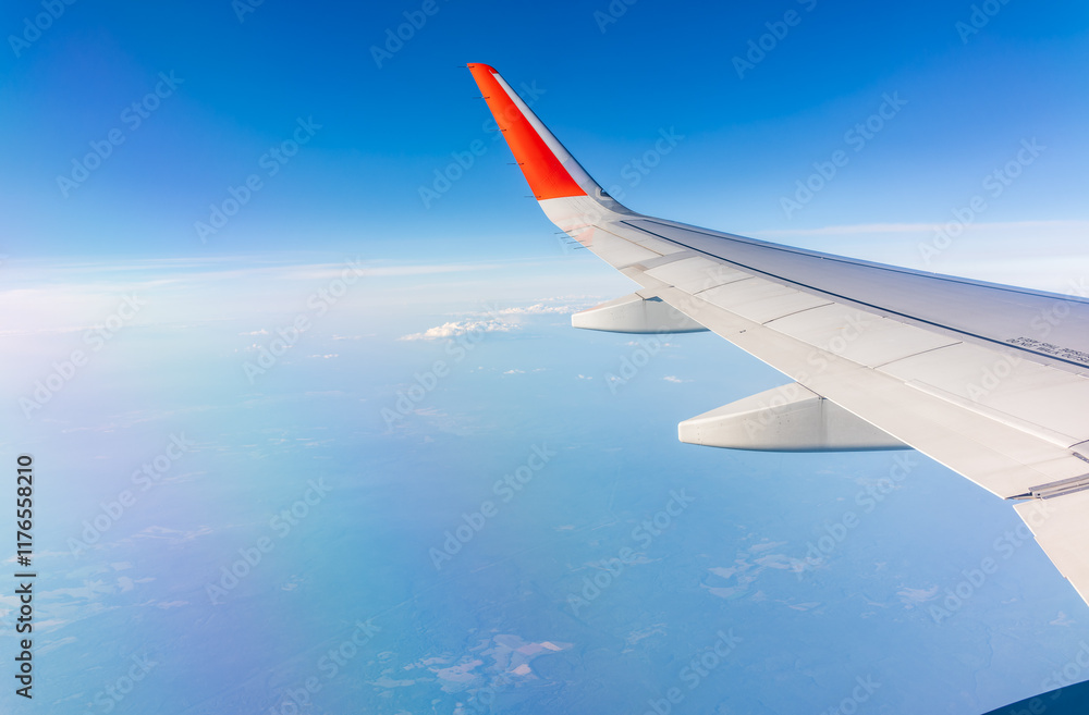 View from the airplane window at a beautiful cloudy sky and the airplane wing View from the airplane window at a beautiful cloudy sky and the airplane wing