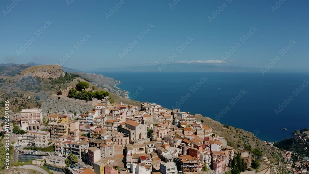 Ascending drone shot from a small town on a mountains peak. Aerial view of typical Italian town in Sicily. Charming historic Castelmola town. Ascending drone shot from a small town on a mountains peak. Aerial view of typical Italian town in Sicily. Charming historic Castelmola town.