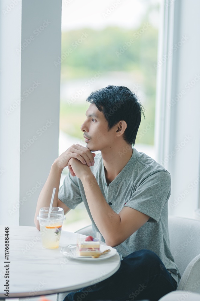 Thoughtful man enjoying a drink while sitting by the window Thoughtful man enjoying a drink while sitting by the window
