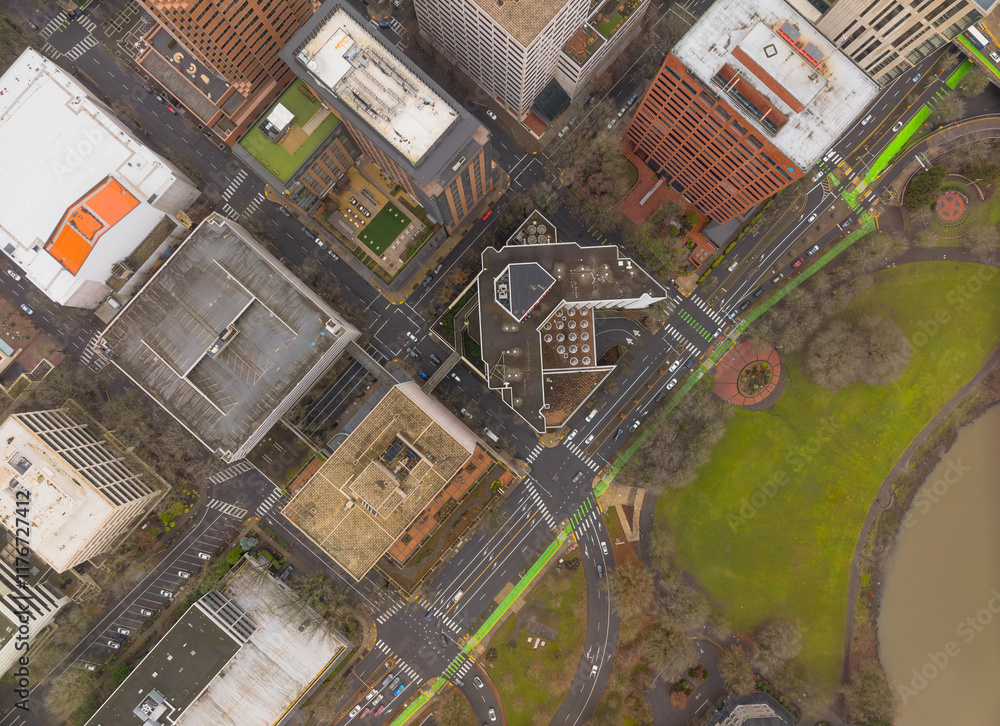 A city street view with a green crosswalk and a large building in the background