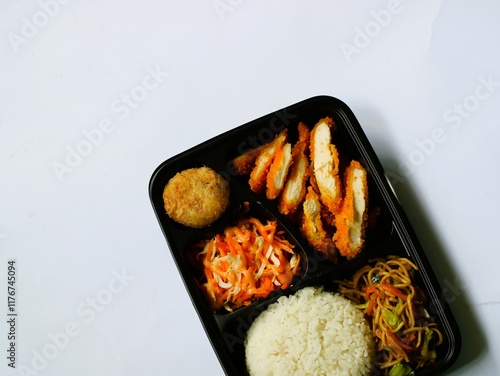 Katsu chicken, rice, noodles, mashed potatoes, vegetable salad, and fritter served on bento box meal isolated white, copy space. Suitable for students and busy worker, home business opprtunity photo