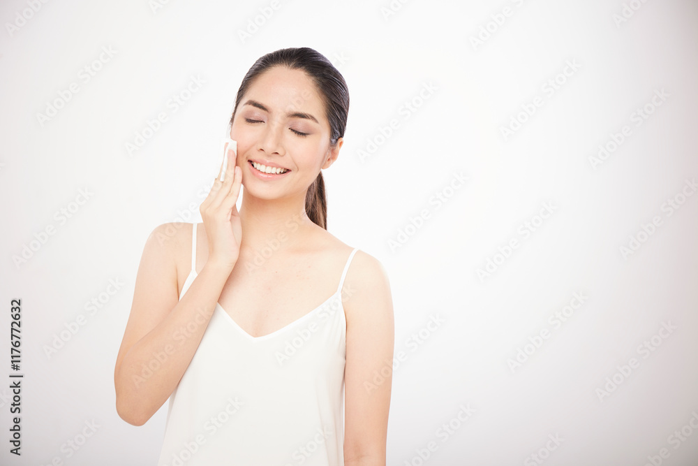 Asian girl use the cotton wool for clean her face on white background Asian girl use the cotton wool for clean her face on white background