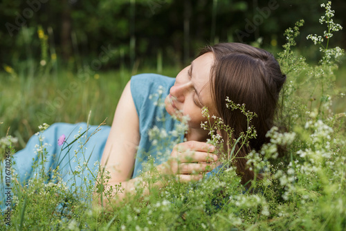 Woman with eyes closed lying at meadow photo