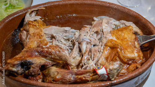 Delicioso cuarto de lechazo asado en horno de leña y cazuela de barro photo