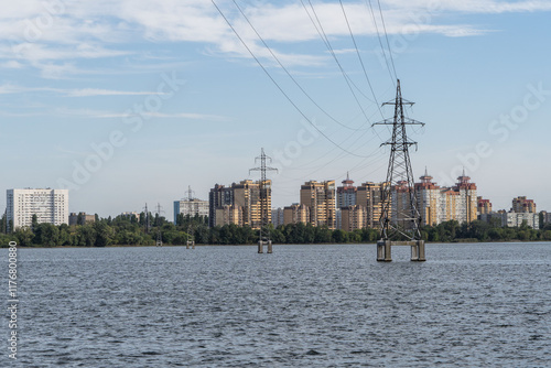 Metal poles of high-voltage power lines in water on concrete base. Voronezh reservoir. Electric cables with insulators on metal supports. Voronezh, Russia - September 8, 2024 photo